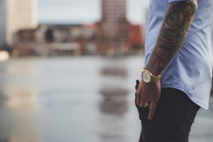 Wristwatch on tattooed arm