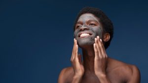 Smiling man using skin cleanser