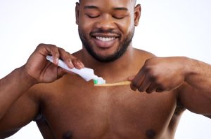 Man putting toothpaste on brush 